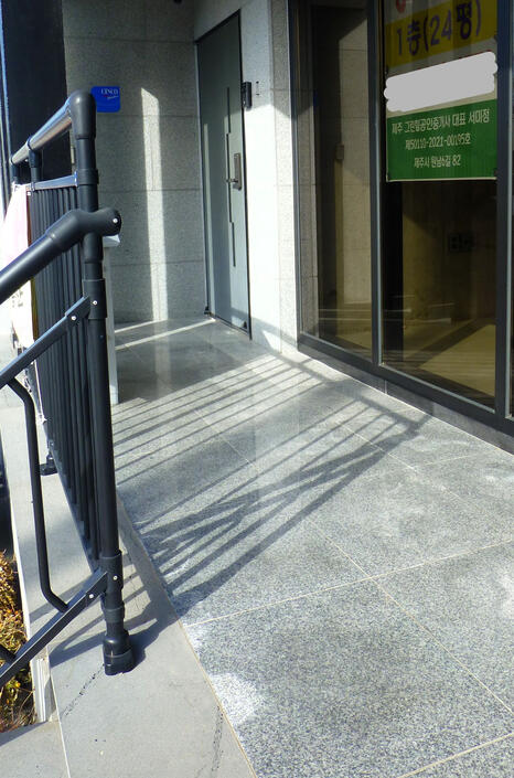 The door of the building is the metal door on your left The door of the building is the metal door on your left
